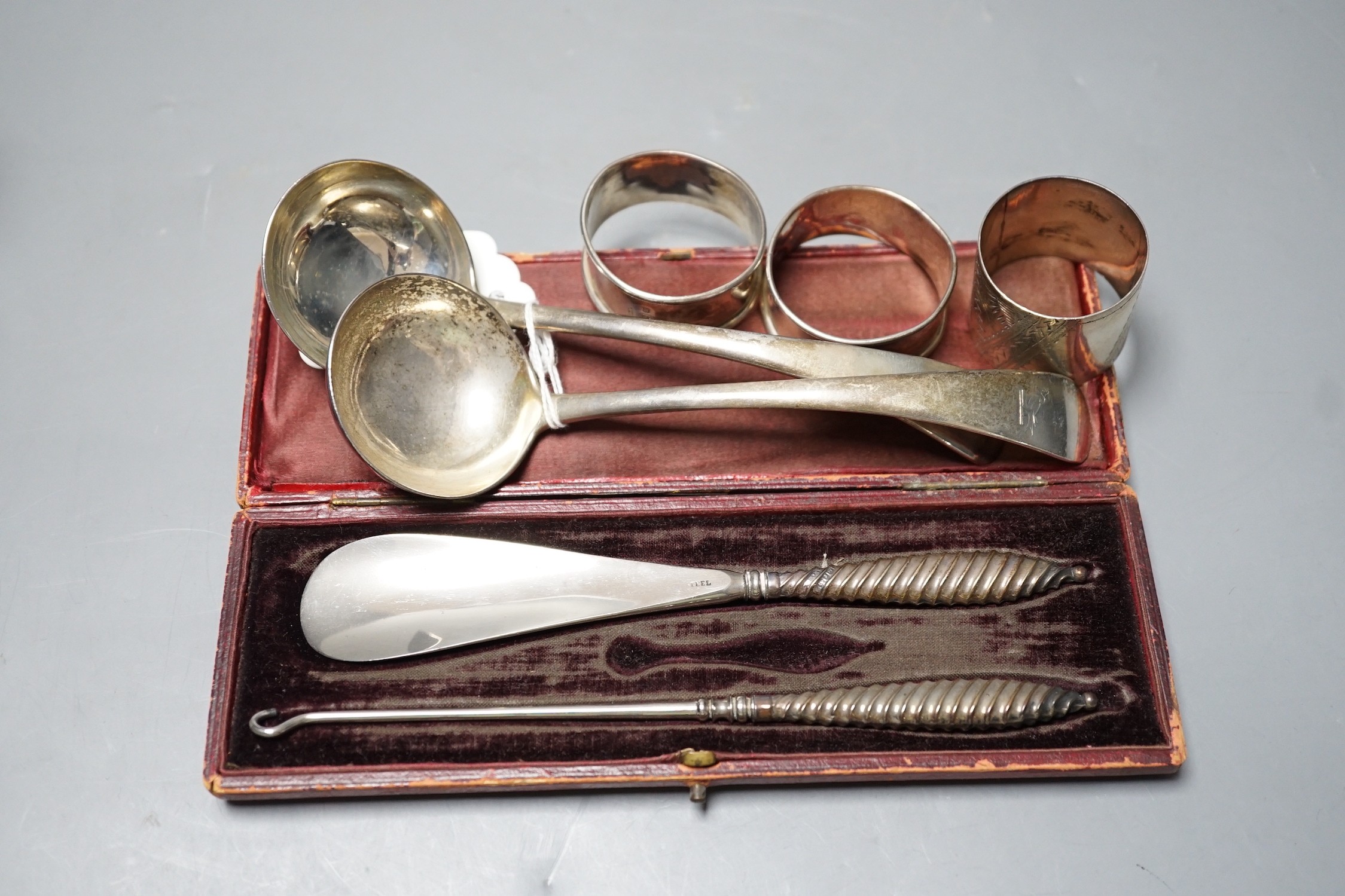 A pair of late Victorian silver Old English pattern sauce ladles, London, 1898, three silver napkin rings and a cased silver handled shoe horn and button hook.